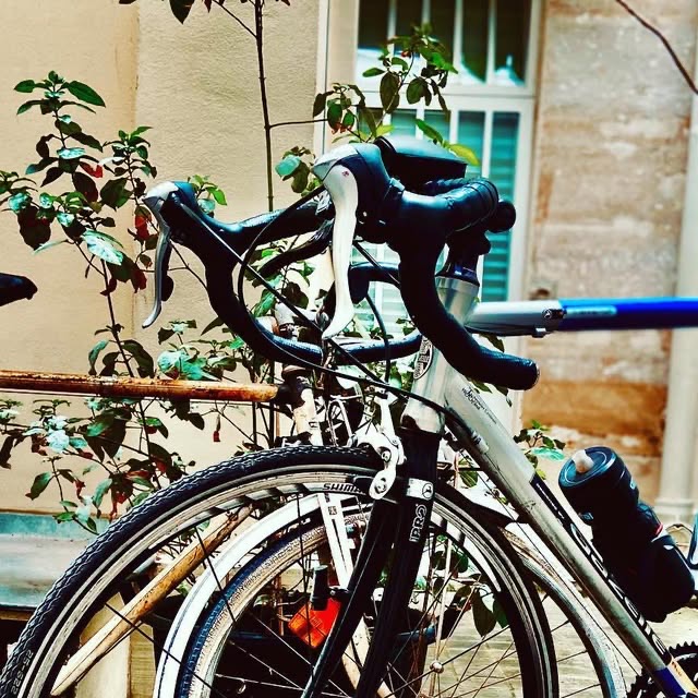 Le guidon d'un vélo de course, dans une cour.